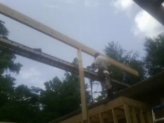 Carpenter setting a ridge beam over a new addition frame — Ice Dam Removal by Roofing Brothers in South Seaville