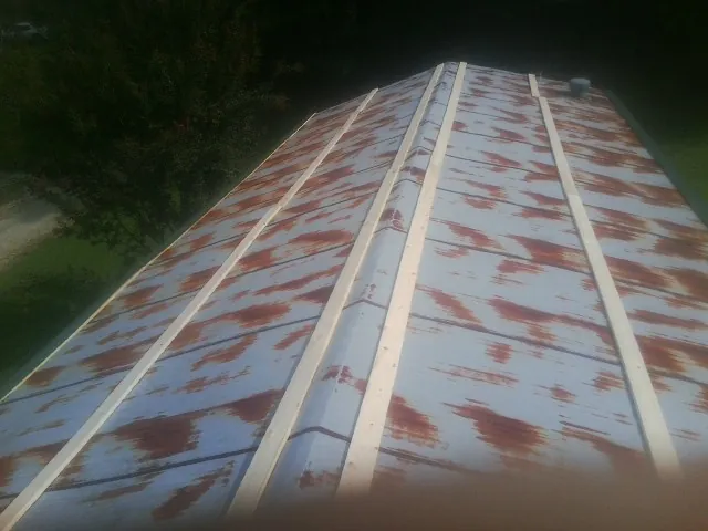 Rusted metal roof panels with new wood purlins before replacement — Storm Damage Roof Repair in South Seaville by Roofing Brothers